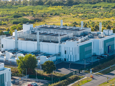 Aerial view of Vantage Data Centers BER1 facility with modern white architecture rooftop cooling infrastructure and surrounding greenery in Ludwigsfelde Brandenburg Germany. Aerial view of Vantage Data Centers BER1 facility with modern white architecture rooftop cooling infrastructure and surrounding greenery in Ludwigsfelde Brandenburg Germany.