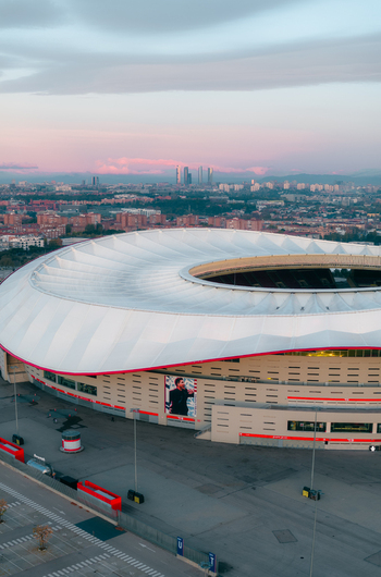 Aerial view of Riyadh Air Metropolitano Stadium with its distinctive white roof and modern architecture set against the urban skyline of Madrid Comunidad de Madrid Spain.