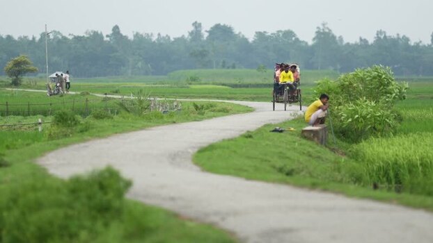 View of a rickshaw on a winding rural road in Bogura Bangladesh.