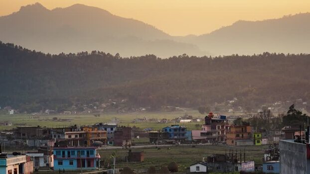 View of a village in a valley with mountains at sunset Nepal.