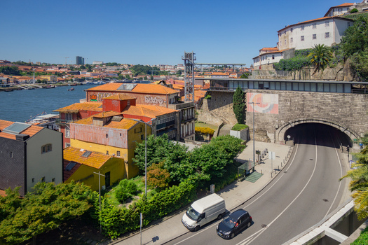 Aerial view of terracotta rooftops cascading towards the Douro River juxtaposed against the modern infrastructure and historic architecture Porto Porto District Portugal. Aerial view of terracotta rooftops cascading towards the Douro River juxtaposed against the modern infrastructure and historic architecture Porto Porto District Portugal.