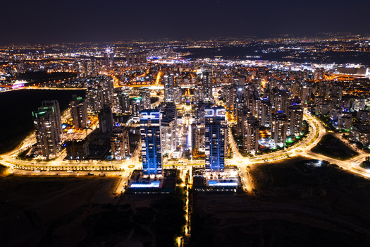 Aerial view of the illuminated skyline of Netanya at night featuring modern skyscrapers glowing city streets and urban infrastructure in Netanya Center District Israel. Aerial view of the illuminated skyline of Netanya at night featuring modern skyscrapers glowing city streets and urban infrastructure in Netanya Center District Israel.