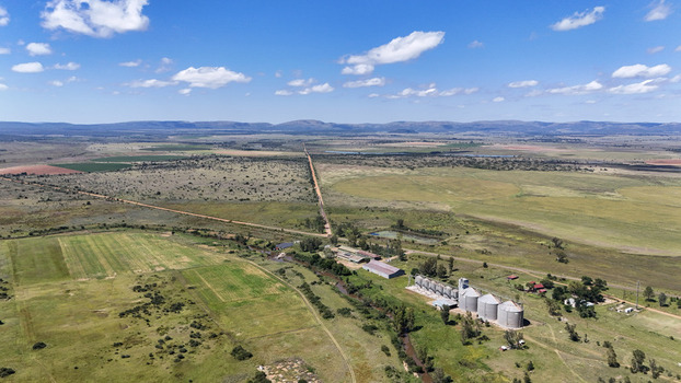 Aerial view of the Alma farm area featuring grain silos agricultural fields and dirt roads under a blue sky in Waterberg District Municipality Limpopo South Africa. Aerial view of the Alma farm area featuring grain silos agricultural fields and dirt roads under a blue sky in Waterberg District Municipality Limpopo South Africa.