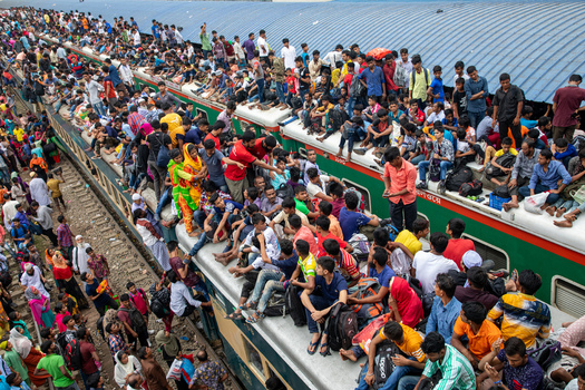 Dhaka Bangladesh 15 June 2018 View of Airport Railway Station with a massive crowd of people sitting on the roofs of trains and standing on the platform during Eid al Fitr travel. Dhaka Bangladesh 15 June 2018 View of Airport Railway Station with a massive crowd of people sitting on the roofs of trains and standing on the platform during Eid al Fitr travel.