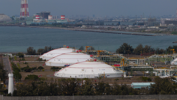 Aerial view of large white LNG storage tanks and industrial infrastructure at the Yong an LNG Terminal along the coast in Xingang Village Kaohsiung City Taiwan.