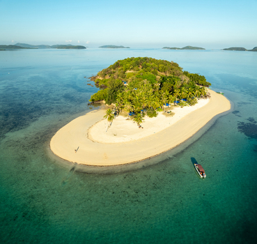 Aerial view of Pass Island featuring a pristine white sand beach lush palm trees and turquoise waters in Coron Philippines. Aerial view of Pass Island featuring a pristine white sand beach lush palm trees and turquoise waters in Coron Philippines.