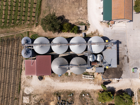 Aerial view of grain silos and agricultural facility surrounded by farmland and rural landscape in Ortezzano Marche Italy. Aerial view of grain silos and agricultural facility surrounded by farmland and rural landscape in Ortezzano Marche Italy.