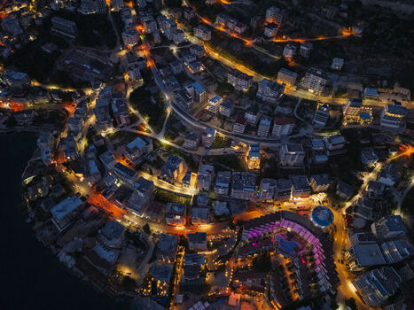 Aerial view of the coastal town of Saranda at night featuring illuminated streets hotels and buildings along the Ionian Sea in Saranda Vlore County Albania. Aerial view of the coastal town of Saranda at night featuring illuminated streets hotels and buildings along the Ionian Sea in Saranda Vlore County Albania.
