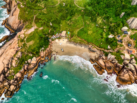 Aerial view of Praia do Gravata featuring a secluded sandy beach turquoise waters rocky cliffs and lush green vegetation in Florianopolis Santa Catarina Brazil. Aerial view of Praia do Gravata featuring a secluded sandy beach turquoise waters rocky cliffs and lush green vegetation in Florianopolis Santa Catarina Brazil.