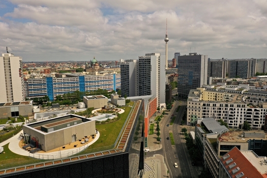 Aerial view of the Axel Springer Neubau with its green roof terrace and the Berlin TV Tower overlooking the urban skyline and city streets in Berlin Berlin Germany. Aerial view of the Axel Springer Neubau with its green roof terrace and the Berlin TV Tower overlooking the urban skyline and city streets in Berlin Berlin Germany.