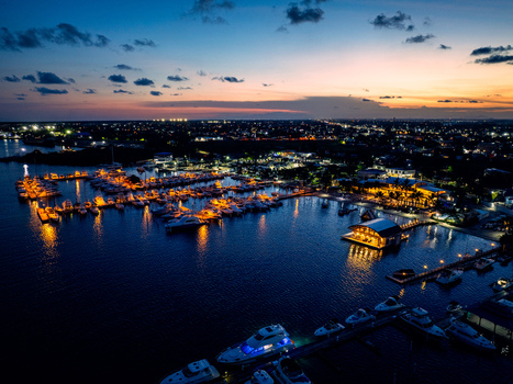 Aerial view of Club Nautico de Santo Domingo Inc. marina at dusk with yachts docked in calm waters illuminated by warm lights in Andres Santo Domingo Dominican Republic. Aerial view of Club Nautico de Santo Domingo Inc. marina at dusk with yachts docked in calm waters illuminated by warm lights in Andres Santo Domingo Dominican Republic.