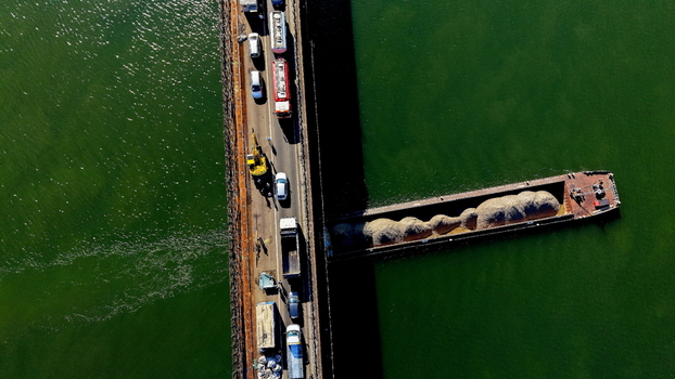 Aerial view of the Smederevo bridge over the Danube river with heavy traffic and a cargo barge carrying gravel passing underneath in Smederevo Podunavlje District Serbia.