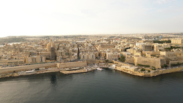Aerial view of the historic city of Valletta with its iconic dome of the Basilica of Our Lady of Mount Carmel stone fortifications and harbor waterfront in Malta. Aerial view of the historic city of Valletta with its iconic dome of the Basilica of Our Lady of Mount Carmel stone fortifications and harbor waterfront in Malta.