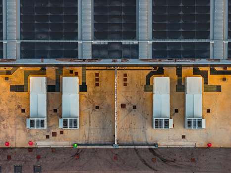 Aerial view of a datacenter roof featuring industrial HVAC units and geometric concrete surfaces in Settecamini Lazio Italy.