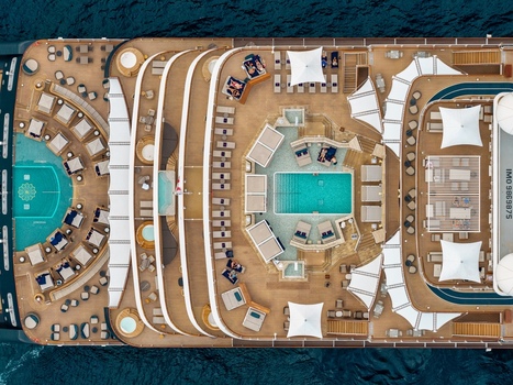 Aerial view of the luxury cruise ship deck featuring swimming pools sun loungers and white umbrellas on the wooden deck in Cannes Provence Alpes Cote d Azur France. Aerial view of the luxury cruise ship deck featuring swimming pools sun loungers and white umbrellas on the wooden deck in Cannes Provence Alpes Cote d Azur France.