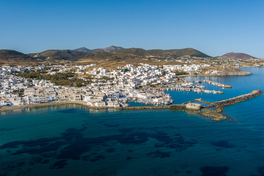 Greece 21 September 2026 Aerial view of the coastal town of Naoussa on Paros island featuring white washed buildings a small harbor with boats and clear blue Aegean Sea waters. Greece 21 September 2026 Aerial view of the coastal town of Naoussa on Paros island featuring white washed buildings a small harbor with boats and clear blue Aegean Sea waters.