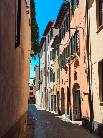 Pisa Italy 27 April 2026 View of a narrow historic street with colorful buildings green shutters and cobblestone pavement under a clear blue sky. Pisa Italy 27 April 2026 View of a narrow historic street with colorful buildings green shutters and cobblestone pavement under a clear blue sky.