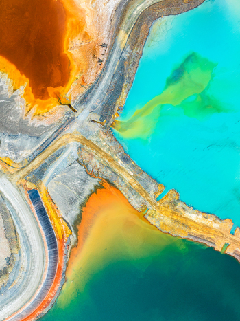 Aerial view of vibrant turquoise and orange mining tailings ponds separated by earthen embankments in the industrial landscape of Andalusia Spain. Aerial view of vibrant turquoise and orange mining tailings ponds separated by earthen embankments in the industrial landscape of Andalusia Spain.