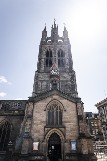 View of the historic St. Nicholas Cathedral tower with its intricate stone architecture clock face and gothic arches in Newcastle upon Tyne England United Kingdom. View of the historic St. Nicholas Cathedral tower with its intricate stone architecture clock face and gothic arches in Newcastle upon Tyne England United Kingdom.