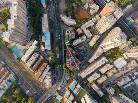 Aerial view of the dense urban landscape of Mumbai featuring high rise residential buildings busy roads construction sites with cranes and railway tracks in Mumbai Maharashtra India. Aerial view of the dense urban landscape of Mumbai featuring high rise residential buildings busy roads construction sites with cranes and railway tracks in Mumbai Maharashtra India.
