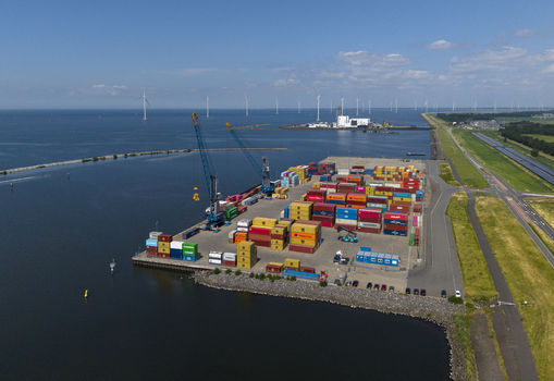 Aerial view of TMA Terminals Lelystad with colorful shipping containers stacked in the port area harbor cranes and wind turbines in Lelystad Flevoland Netherlands. Aerial view of TMA Terminals Lelystad with colorful shipping containers stacked in the port area harbor cranes and wind turbines in Lelystad Flevoland Netherlands.