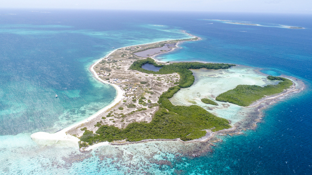 Aerial view of Los Roques archipelago with turquoise waters coral reefs and lush green vegetation on a sandy island Los Roques Dependencias Federales Venezuela. Aerial view of Los Roques archipelago with turquoise waters coral reefs and lush green vegetation on a sandy island Los Roques Dependencias Federales Venezuela.