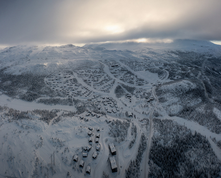 Aerial view of Gaustablikk Fjellresort with snow covered cabins ski slopes and pine forests under a cloudy winter sky in Rjukan Telemark Norway. Aerial view of Gaustablikk Fjellresort with snow covered cabins ski slopes and pine forests under a cloudy winter sky in Rjukan Telemark Norway.