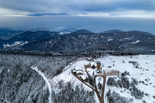 Aerial view of the snow covered Hornisgrinde mountain landscape with the hotel and tower near Mummelsee surrounded by pine forests in Seebach Baden Wurttemberg Germany. Aerial view of the snow covered Hornisgrinde mountain landscape with the hotel and tower near Mummelsee surrounded by pine forests in Seebach Baden Wurttemberg Germany.
