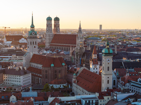 Aerial view of the historic skyline featuring the Frauenkirche cathedral and New Town Hall towers during golden hour sunset in Munich Bavaria Germany. Aerial view of the historic skyline featuring the Frauenkirche cathedral and New Town Hall towers during golden hour sunset in Munich Bavaria Germany.