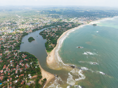 Aerial view of the Nilwala River mouth meeting the Indian Ocean with sandy beaches and urban coastal development in Matara Southern Province Sri Lanka. Aerial view of the Nilwala River mouth meeting the Indian Ocean with sandy beaches and urban coastal development in Matara Southern Province Sri Lanka.