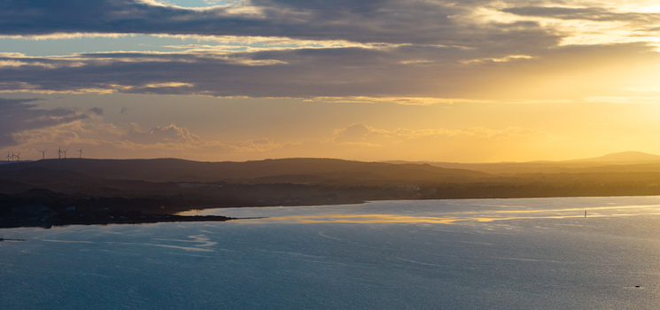 Aerial view of the coastal landscape near Camp Quaranup at sunset with wind turbines on the horizon in Vancouver Peninsula Western Australia Australia. Aerial view of the coastal landscape near Camp Quaranup at sunset with wind turbines on the horizon in Vancouver Peninsula Western Australia Australia.