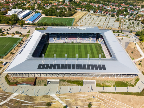 Szekesfehervar Hungary 14 August 2026 Aerial view of MOL Arena Sostoi Stadion with empty football pitch grandstands and modern roof structure in an urban sports complex.