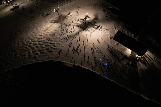 Aerial view of Les Crosets ski resort at night with people gathered near the illuminated ski lift station and snow covered slopes Val d Illiez Valais Switzerland. Aerial view of Les Crosets ski resort at night with people gathered near the illuminated ski lift station and snow covered slopes Val d Illiez Valais Switzerland.