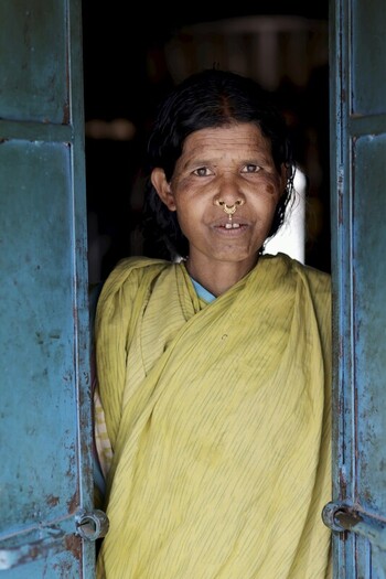 Odisha India 26 March 2026 View of a local woman framed by the weathered teal colored doorway her serene expression a beacon of resilience and quiet strength. Odisha India 26 March 2026 View of a local woman framed by the weathered teal colored doorway her serene expression a beacon of resilience and quiet strength.