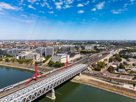 Aerial view of Rakoczi Bridge over the Danube in Budapest with Mupa the National Theatre tram lines roads and summer traffic in the modern Hungarian cityscape. Aerial view of Rakoczi Bridge over the Danube in Budapest with Mupa the National Theatre tram lines roads and summer traffic in the modern Hungarian cityscape.