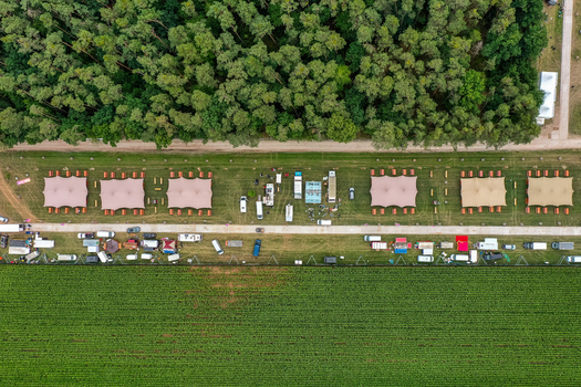 Herzogenaurach Germany 25 July 2025 Aerial view of the Open Beatz Festival site featuring white event tents and vehicles situated next to a dense green forest. Herzogenaurach Germany 25 July 2025 Aerial view of the Open Beatz Festival site featuring white event tents and vehicles situated next to a dense green forest.