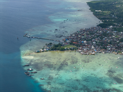 Aerial view of a vibrant coastal town where the turquoise waters meet the dense buildings near Karimunjawa Town Square Karimunjawa Central Java Indonesia. Aerial view of a vibrant coastal town where the turquoise waters meet the dense buildings near Karimunjawa Town Square Karimunjawa Central Java Indonesia.
