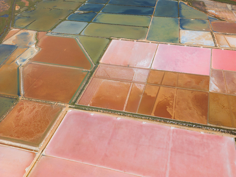 Aerial view of the colorful salt evaporation ponds at Salines des Trenc with geometric patterns and vibrant hues in Campos Islas Baleares Spain. Aerial view of the colorful salt evaporation ponds at Salines des Trenc with geometric patterns and vibrant hues in Campos Islas Baleares Spain.