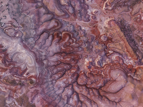 Aerial view of the colorful layered clay formations of the Bentonite Hills with intricate erosion patterns and vibrant red purple and white earth tones in Hanksville Utah United States.