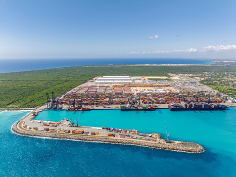 Aerial view of the DP World Dominicana container terminal with cargo ships shipping containers and cranes along the turquoise coastline in Boca Chica Santo Domingo Dominican Republic. Aerial view of the DP World Dominicana container terminal with cargo ships shipping containers and cranes along the turquoise coastline in Boca Chica Santo Domingo Dominican Republic.