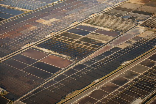Aerial view of salt pans with geometric patterns and varying water levels in the coastal landscape of Rio de Janeiro Rio de Janeiro Brazil. Aerial view of salt pans with geometric patterns and varying water levels in the coastal landscape of Rio de Janeiro Rio de Janeiro Brazil.