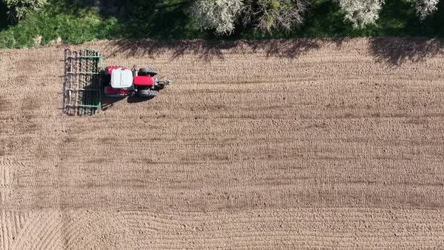 Aerial view of Tractor tilling the field France.