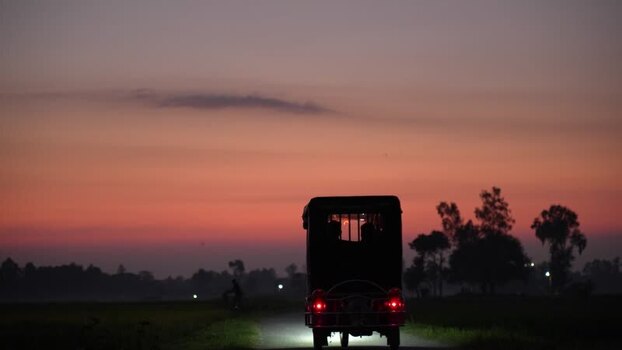 View of a three wheeled vehicle on a road at sunset Bangladesh. View of a three wheeled vehicle on a road at sunset Bangladesh.