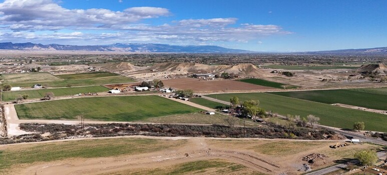 Aerial view of verdant fields meet arid landscapes under a vast blue sky contrasting the textures of rural life Fruita Colorado United States. Aerial view of verdant fields meet arid landscapes under a vast blue sky contrasting the textures of rural life Fruita Colorado United States.