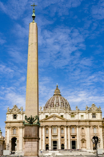View of the Vatican Obelisk and St. Peter s Basilica under a blue sky with soft clouds in Rome Lazio Italy. View of the Vatican Obelisk and St. Peter s Basilica under a blue sky with soft clouds in Rome Lazio Italy.