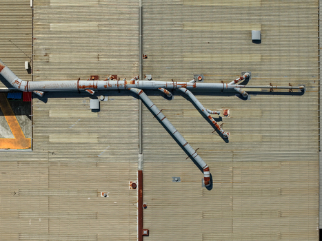 Aerial view of industrial factory roof with complex metal piping systems ventilation ducts and corrugated metal surfaces in Kilsyth Victoria Australia. Aerial view of industrial factory roof with complex metal piping systems ventilation ducts and corrugated metal surfaces in Kilsyth Victoria Australia.