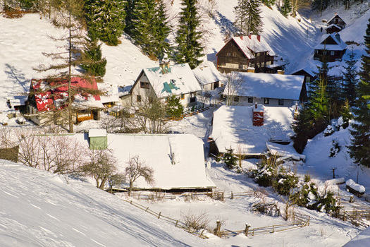 View of snow blanketed roofs of cabins nestled among the evergreens a winter wonderland scene of rustic charm and tranquility Moce Banska Bystrica Region Slovakia.