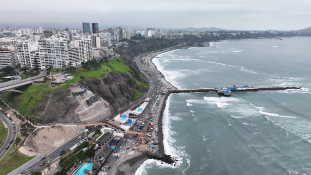Aerial view of the Barranco district coastline featuring dramatic cliffs modern buildings a pier extending into the Pacific Ocean and a coastal highway in Barranco Lima Province Peru. Aerial view of the Barranco district coastline featuring dramatic cliffs modern buildings a pier extending into the Pacific Ocean and a coastal highway in Barranco Lima Province Peru.
