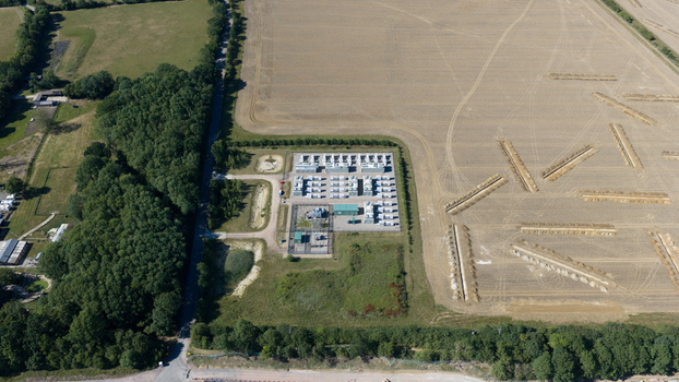 Aerial view of Pelham Storage Limited facility with rows of battery storage units and electrical infrastructure surrounded by fields and woodland in Bishop s Stortford England United Kingdom. Aerial view of Pelham Storage Limited facility with rows of battery storage units and electrical infrastructure surrounded by fields and woodland in Bishop s Stortford England United Kingdom.