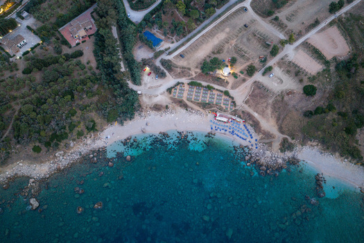 Aerial view of Riserva Naturale Orientata dello Zingaro featuring a beach with turquoise water rocky coastline Mediterranean vegetation and parking area in San Vito Lo Capo Sicilia Italy. Aerial view of Riserva Naturale Orientata dello Zingaro featuring a beach with turquoise water rocky coastline Mediterranean vegetation and parking area in San Vito Lo Capo Sicilia Italy.
